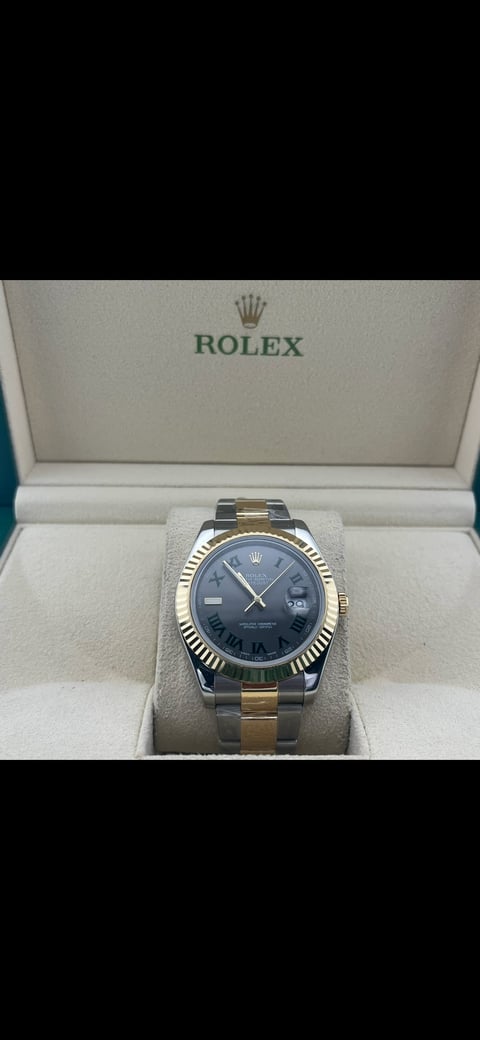 Rolex watch with two-tone metal bracelet and blue dial displayed in official Rolex presentation box with cream interior